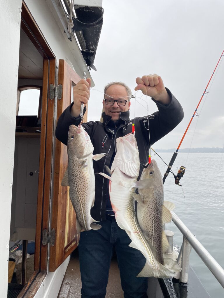 Mand har fanget tre fisk på en fisketur på båden Viking